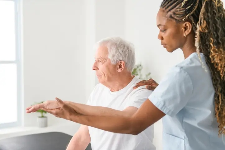 Shreveport Manor physiotherapist helping senior man with physical therapy stretches in Shreveport, LA