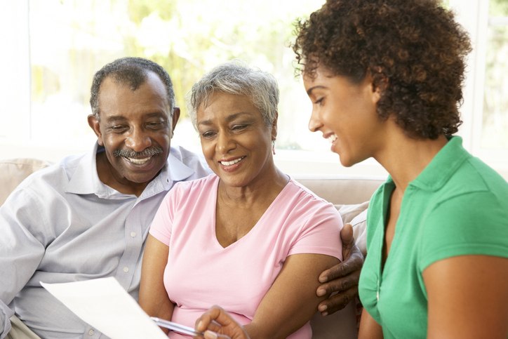 A woman and two men are discussing long-term care insurance with a document in Shreveport, LA