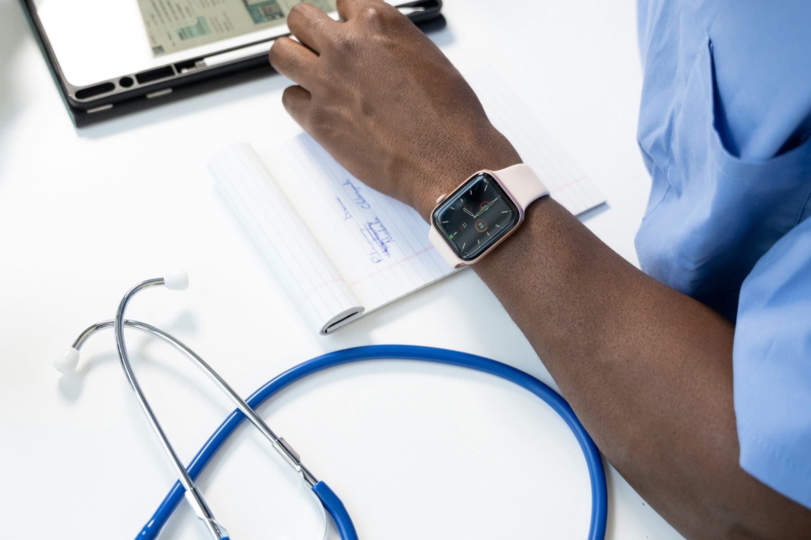 A clinician reviews patient care records beside monitoring equipment